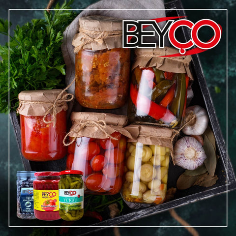Vorschaubild zur Marke Beyço mit eingelegtem Gemüse und Pasten in Einmachgläsern in einer Holzkiste, umgeben von Gewürzen. Dazu Produktfotos von schwarzen Oliven, eingelegten Chilis und einer Gewürzpaste. Oben rechts das Beyço-Logo